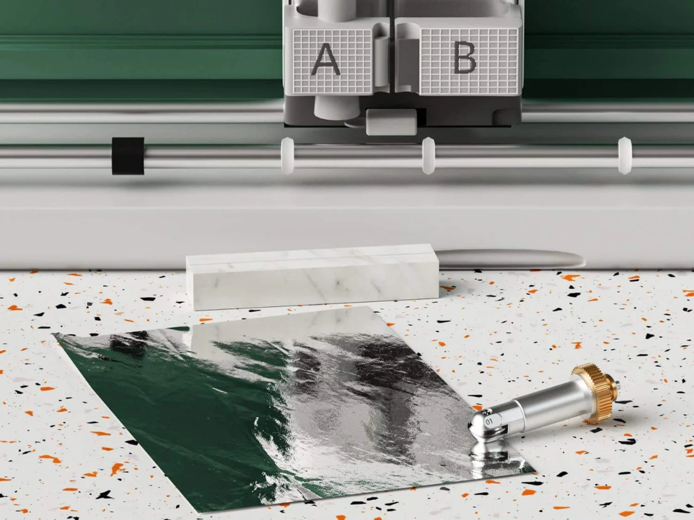 Plan de travail d’atelier : machine de découpe, feuille métallisée et outil de rainage Wellkitch.